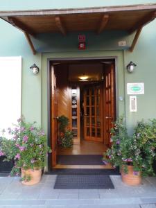 una porta d'ingresso di una casa con due piante di Hotel Italia a Moneglia