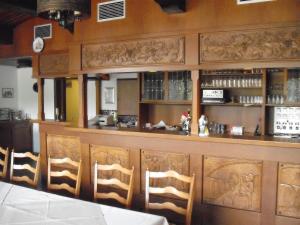 ein Esszimmer mit einer Bar mit Holzstühlen in der Unterkunft Hotel Weinhaus Liesertal in Maring-Noviand