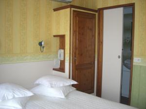 a bedroom with a bed with white pillows and a mirror at La Marjolaine in Juan-les-Pins