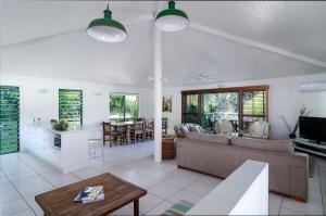 a living room filled with furniture and a tv at The Retreat Beach Houses in Peregian Beach