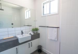 a white bathroom with a sink and a mirror at BIG4 Castlemaine Gardens in Castlemaine +45 photos