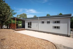 a white house with a gambrel roof at BIG4 Castlemaine Gardens in Castlemaine