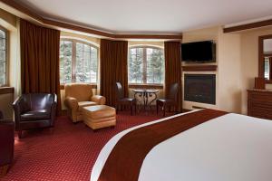 a bedroom with a large bed and a living room at Tivoli Lodge in Vail