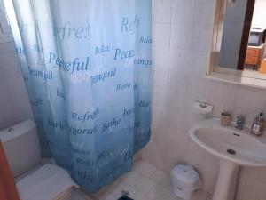 a bathroom with a shower curtain with writing on it at CorfuGrace in Sidari