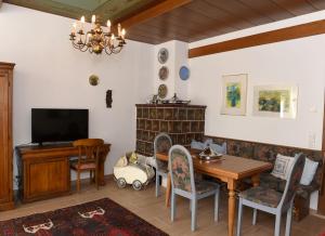 a living room with a table and chairs and a television at Haus Hoffmann in Sonnenalpe Nassfeld