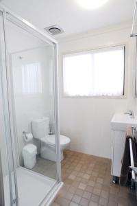 a bathroom with a toilet, sink and tub at Wollongong Surf Leisure Resort in Wollongong