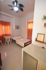 Cette chambre comprend deux lits et un ventilateur de plafond. dans l'établissement Las Residencias Bed And Breakfast, à Puerto Princesa