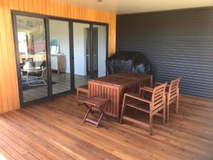 a wooden table and two chairs on a deck at Villa 1 in Port Campbell