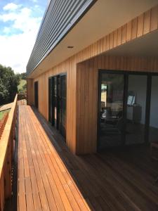 a wooden deck with glass doors on a house at Villa 1 in Port Campbell