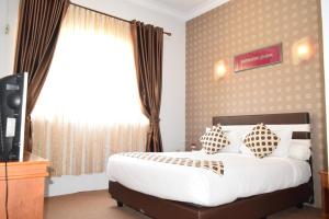 a hotel room with a bed and a television at Jambura Inn in Gorontalo