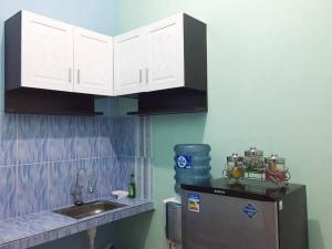 巴圖的住宿－Villa Aviation by Masterpiece Villa，厨房配有白色橱柜、水槽和冰箱。
