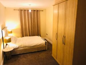 Dormitorio pequeño con cama y vestidor en Modern Apartment By River Thames en Londres