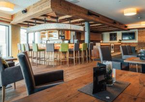 Cette chambre comprend un bar avec des chaises et une table. dans l'établissement Hotel Garni Alpenjuwel Residenz, à Serfaus