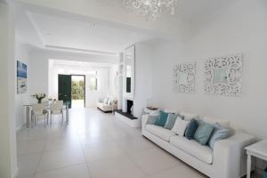 a white living room with a couch and a table at #Luxlikehome - A&M Summer Villa in Pefkohori