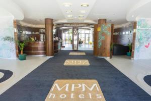 a large room with a walkway and a large clock at MPM Hotel Arsena - Ultra All Inclusive in Nesebar