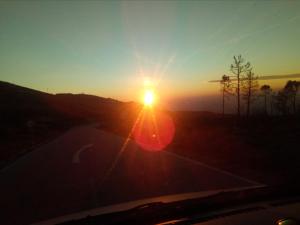 a sunset with the sun setting over a road at Albergaria Senhora do Espinheiro in Seia