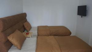 un sofá y una silla en una habitación en Al Barra Syariah Hotel, en Bukittinggi