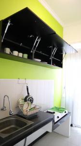 cocina con fregadero y pared verde en Villa All New Casa Grande by Masterpiece Villa, en Batu