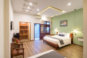 a hotel room with a bed and a television at Le Printemps d' An Bang in Hoi An