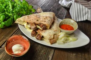 einen Teller mit einem Burrito und einer Soße in der Unterkunft Guesthouse Les in Brežice