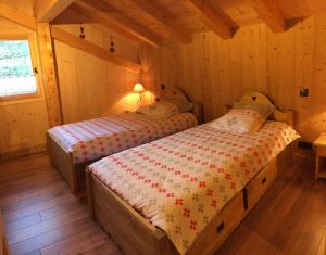 サモエンヌにあるChalet Lilalpes SPAのキャビン ベッド2台付きのベッドルーム1室