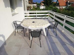 une table blanche et des chaises sur un balcon dans l'établissement ApartmentMR, à Maribor