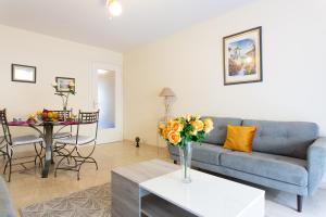 a living room with a couch and a table with a vase of flowers at Palais Royal YourHostHelper in Cannes