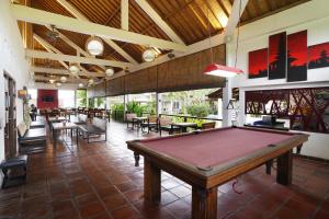 a pool table in a room with tables and chairs at Casa Asia in Uluwatu