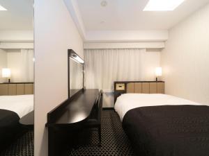 a hotel room with two beds and a mirror at APA Hotel Kyoto Ekikita in Kyoto