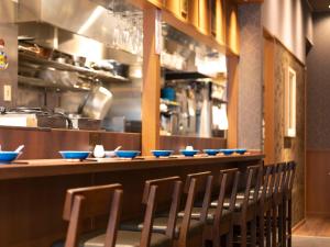 a row of chairs sitting at a bar with blue bowls at APA Hotel Kyoto Ekikita in Kyoto