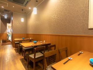 a dining room with wooden tables and chairs at APA Hotel Kyoto Ekikita in Kyoto