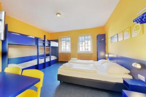 a bedroom with two bunk beds and a table and chairs at Bed'nBudget Expo-Hostel Rooms in Hannover