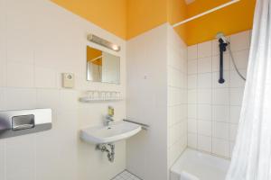a bathroom with a sink and a shower at Bed'nBudget Expo-Hostel Rooms in Hannover