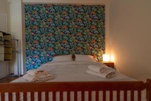 ein Bett mit Handtüchern darauf mit einer großen Blumenwand in der Unterkunft Urban Jungle in Athen
