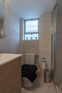 ein Bad mit einem WC, einem Waschbecken und einem Fenster in der Unterkunft Urban Jungle in Athen