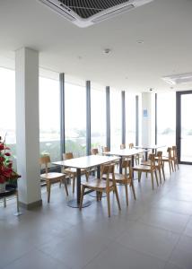 a row of tables and chairs in a room with windows at Citrip Hotel Simpang Lima in Semarang