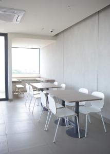 a conference room with tables and white chairs at Citrip Hotel Simpang Lima in Semarang