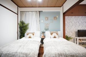 two beds in a room with a window at Naha Southerlies Condominium Kumoji in Makishimachi +48 photos