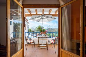 a patio with a table and chairs and an umbrella at Casa Herminia in Frigiliana
