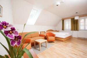 a living room with a bed and a couch at Winzerhof - Gästehaus Stöger in Dürnstein