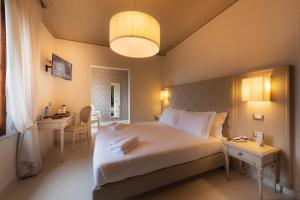 a bedroom with a large white bed and a desk at Villa Elda Boutique Hotel in Siena