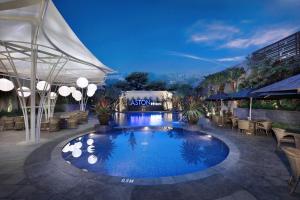 a swimming pool at night with tables and chairs at ASTON Inn Batu in Batu