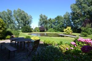 een tuin met tafels en banken en een vijver bij Strandläufer in Reitland