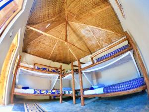 two bunk beds in a room with a roof at OM Hostel Bunyonyi in Kabale