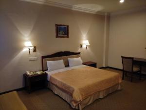 سرير أو أسرّة في غرفة في King Park Hotel Tawau