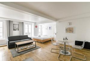 a living room with a couch and a bed at 50m2 rue rambuteau/Pompidou/Marais/Hôtel de Ville in Paris