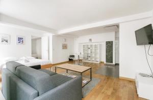 a living room with a couch and a bed at 50m2 rue rambuteau/Pompidou/Marais/Hôtel de Ville in Paris