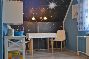 una mesa y sillas en una habitación infantil con una pared estelar en Ferienhaus _Hasenland_, en Kerkwitz