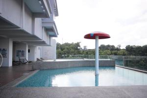 a pool with an umbrella in the middle of a building at Sunny Seaview@Icon Residence in Kuala Terengganu