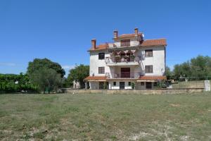 a large house with a grass field in front of it at Apartments Smolica in Labin